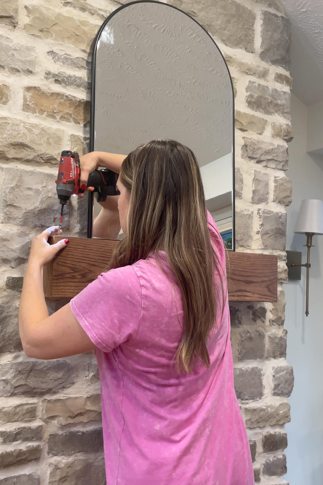 Using screws to hang garland from a fireplace mantel.